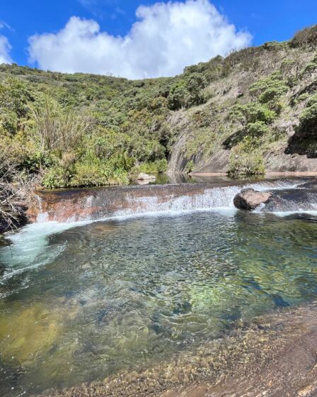 poço de uma pequena cachoeira com vegetação ao fundo, imagem de uma cachoeira no parque nacional do caparaó